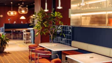 A restaurant interior with booths, tables, and hanging lights.