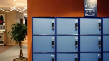 A row of blue lockers numbered 01 to 10, with a sign above detailing locker usage instructions.