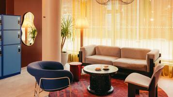 Una sala de estar moderna con un sofá, sillones, una mesa de centro y un archivador azul.