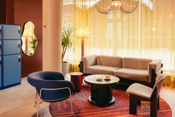 Una sala de estar moderna con un sofá, sillones, una mesa de centro y un archivador azul.