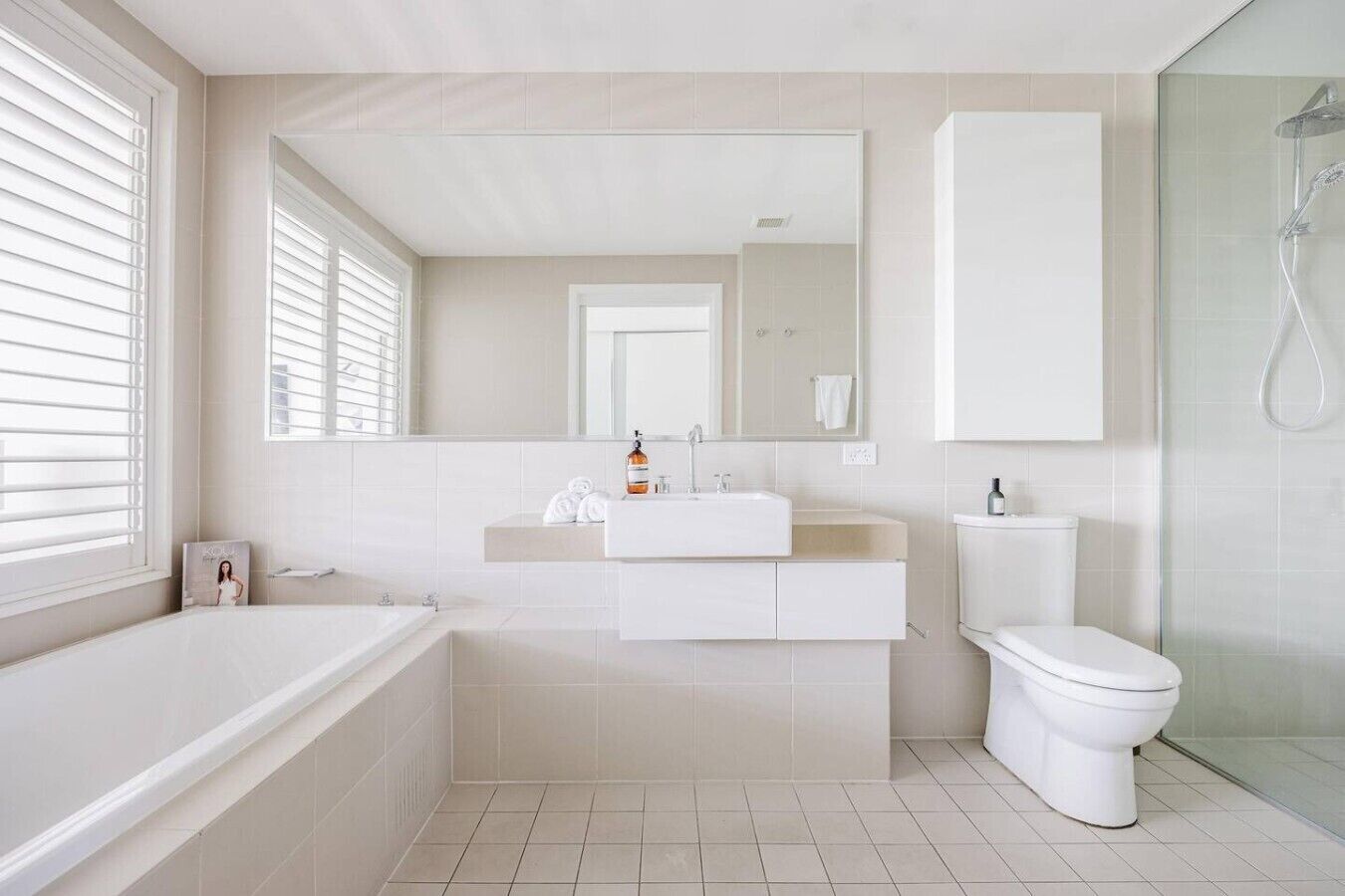 A modern bathroom with a bathtub, a sink, a toilet, and a shower.