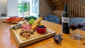 A wooden table with a charcuterie board, wine bottle, and glasses. - The Cottage, Les Chouettes, Dordogne Valley where memories are made (Trémolat)