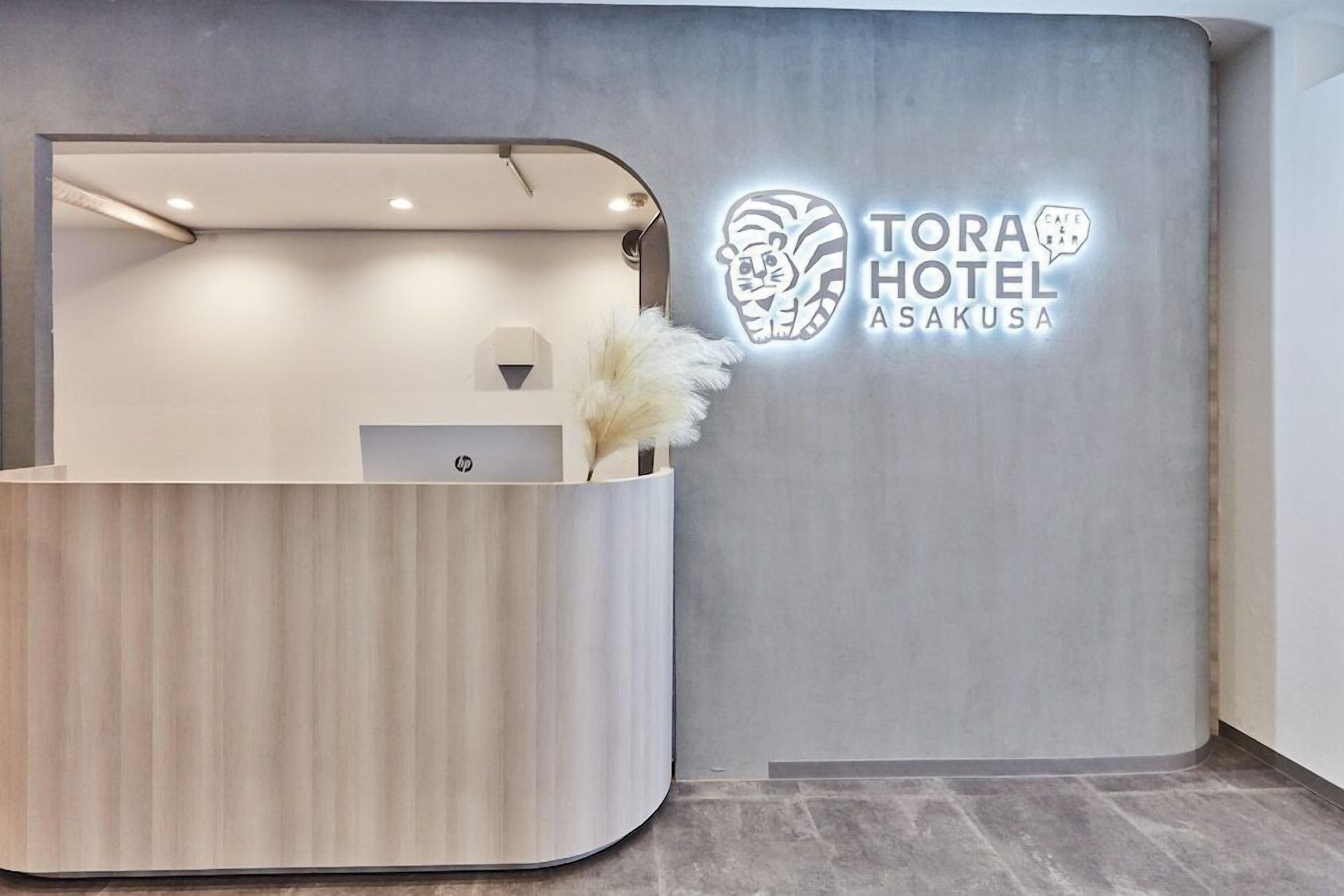 Eine moderne Rezeption im Tora Hotel Asakusa mit einem Logo an der Wand.