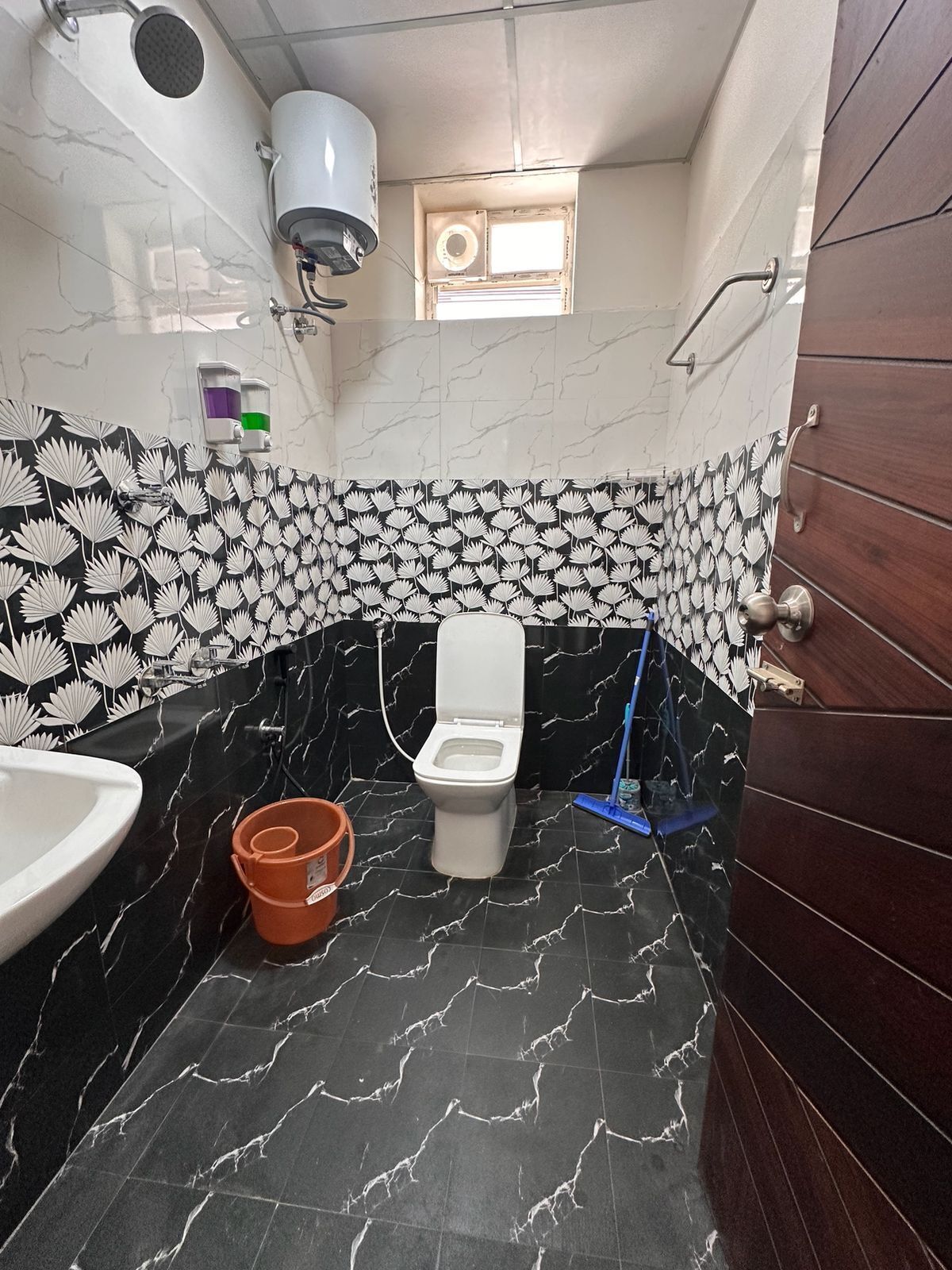 Une salle de bain avec des toilettes, un lavabo et une douche.