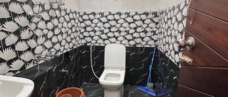 Une salle de bain avec des toilettes, un lavabo et une douche.