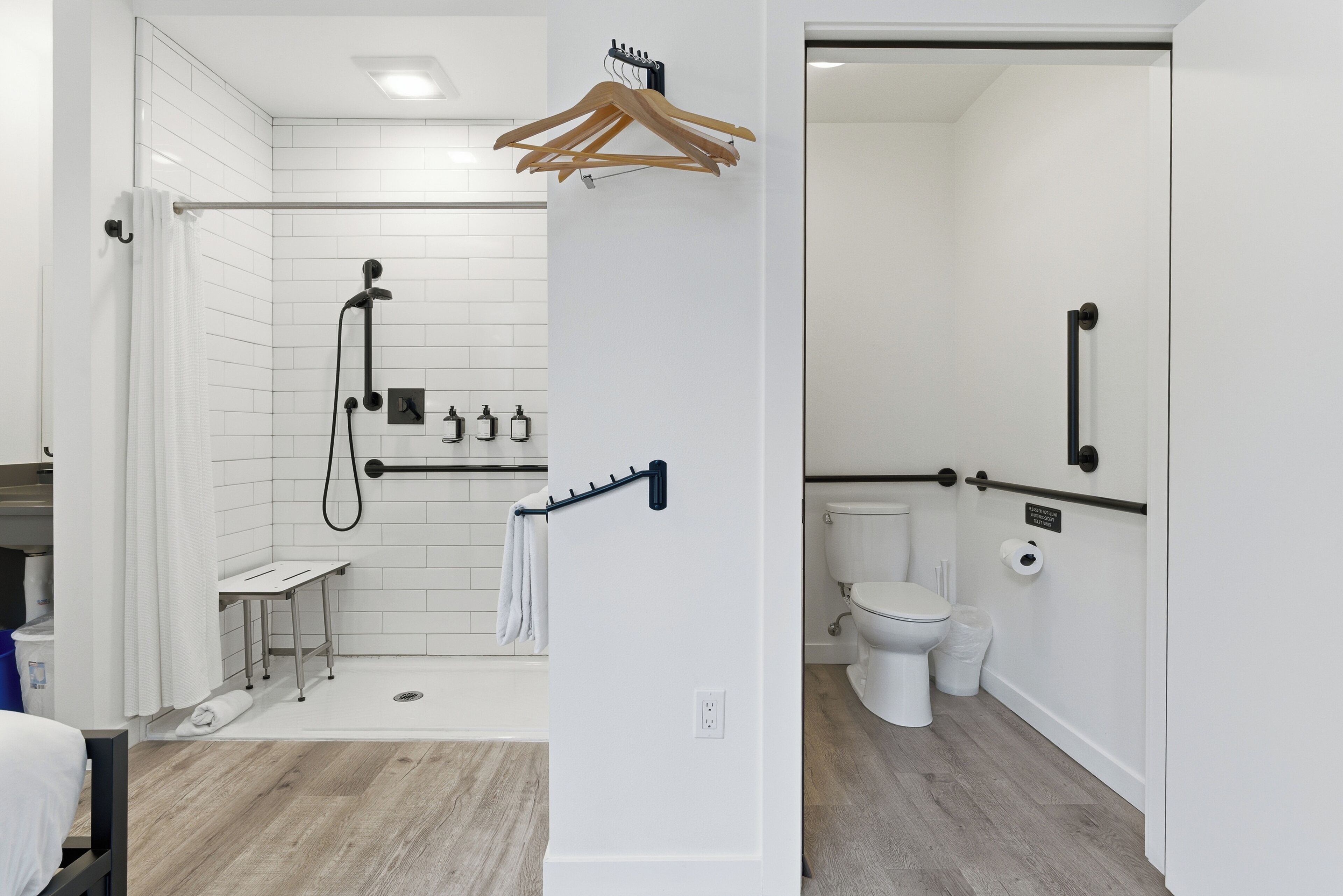 A modern bathroom with a shower, toilet, and sink.