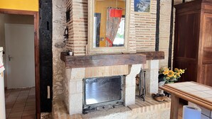 A rustic fireplace with a mirror above it, a wooden mantel, and a tiled floor. - 210 m2 villa between nature and bastide in Rives (Rives)