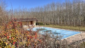 A small building with a tiled roof, a swimming pool, and a forested area in the background. - 210 m2 villa between nature and bastide in Rives (Rives)