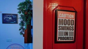 Una puerta roja con un letrero de precaución sobre cambios de humor.