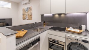A modern kitchen with a dishwasher, oven, and a washing machine. - Bright 2-Bed Apartment in Las Letras, Madrid (Madrid)