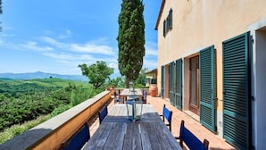 Eine Terrasse mit Tisch und Stühlen mit Blick auf eine schöne Landschaft.