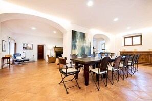 A spacious dining area with a long table and chairs, a fireplace, and a large abstract painting on the wall. - Villa Beltramonto by MMega (Tuscany)