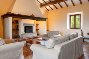 Una sala de estar acogedora con chimenea, sofás y una ventana con vistas.