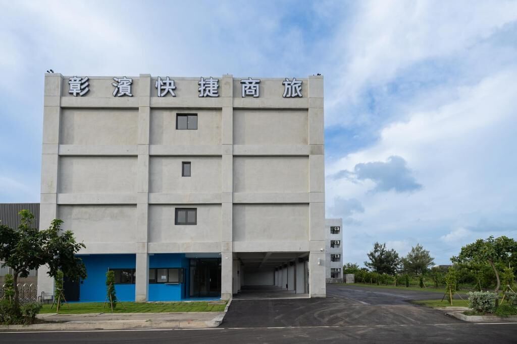 A multi-story building with a flat facade and a blue entrance.