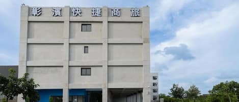 A multi-story building with a flat facade and a blue entrance.