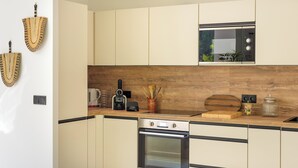 Eine moderne Küche mit weißen Schränken, einem eingebauten Backofen, einer Mikrowelle und einer Holzarbeitsplatte.