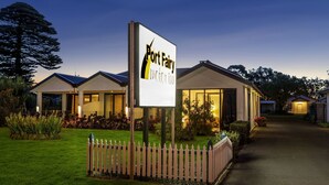 A hotel named Port Fairy Motor Inn with a well-lit entrance, a picket fence, and a landscaped garden. - Port Fairy Motor Inn (Port Fairy)