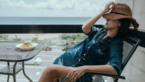 A person seated at a table with a plate of food, overlooking a view of the ocean and a road. - Sasa Nor Lamour B B (Hengchun)