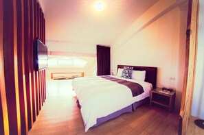 A hotel room with a bed, bedside table, and a TV mounted on the wall. - Sasa Nor Lamour B B (Hengchun)