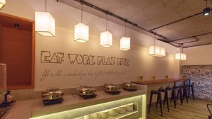 Un espace cuisine moderne avec un comptoir où sont exposés des ustensiles de cuisine et un slogan inscrit sur le mur.