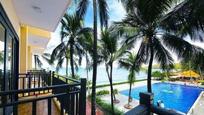 A poolside view with a clear view of the ocean, palm trees, and a swimming pool. - Hon Rom 1 Resort (Phan Thiet)