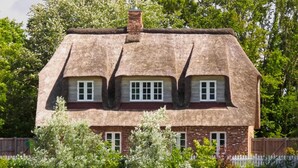 A traditional thatched-roof house with three windows and a chimney. - 5-Star Thatched Holiday Home "Emmas Hus" with Sauna and Fireplace (Pellworm)
