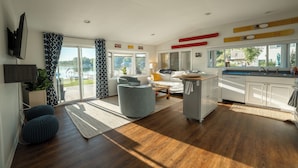 A modern kitchen with a built-in oven, a dining area with a table and chairs, and a large sliding glass door leading to a deck.