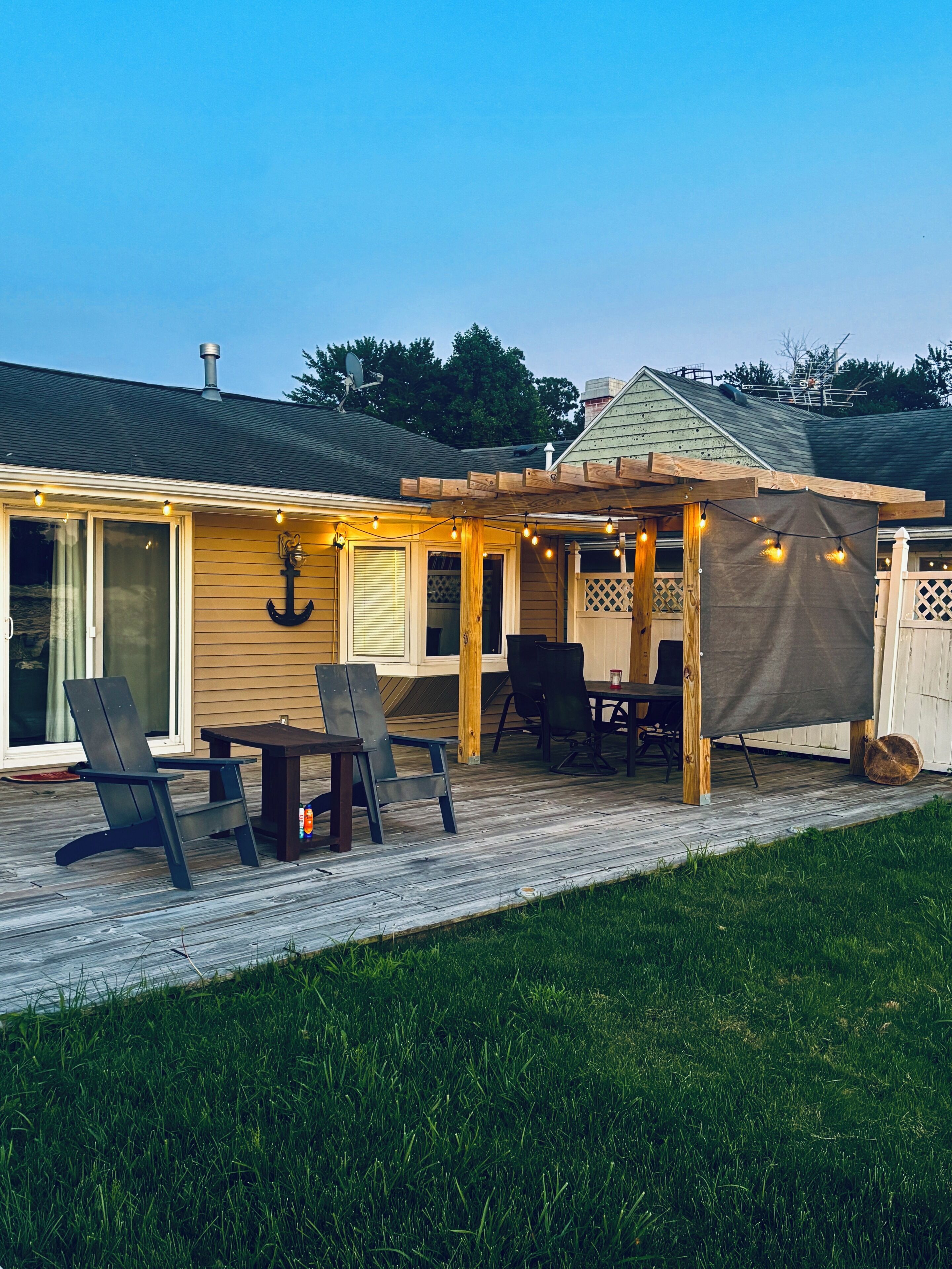 A covered patio with outdoor furniture, a pergola, and string lights.