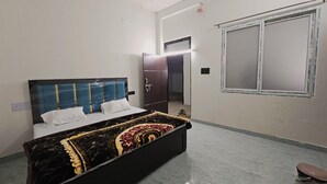 Ein Schlafzimmer mit Bett, Kleiderschrank, Fenster und Tür.