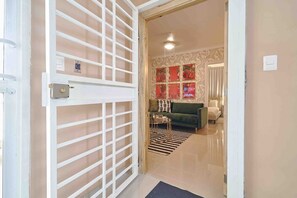 An open door leading to a living room with a sofa, a coffee table, and a patterned rug. - ®{The-Comfty-Spot} Experience @SD +WiFi (Santo Domingo)