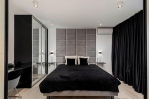 A modern bedroom with a large bed, a glass partition, and a black curtain. - Diamonds Apartment (Kraków)