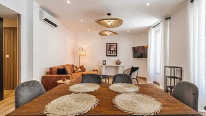 A dining area with a wooden table, woven placemats, and modern chairs. - Magnificent Apartment - AC- 2br- 4P - Cannes (Cannes)