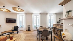 A modern living room with a dining area, large windows, and a TV. - Magnificent Apartment - AC- 2br- 4P - Cannes (Cannes)