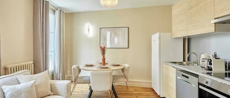 A modern kitchen with a dining area, a sofa, and a coffee table.