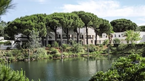 A modern building with a courtyard featuring a pond and trees. - Club Belambra La Grande Motte (La Grande-Motte)
