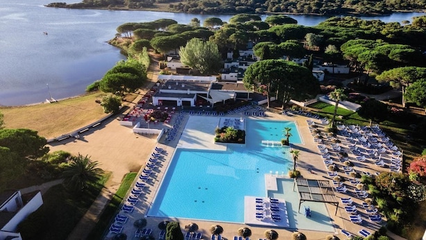An aerial view of a resort with a large swimming pool, sun loungers, and a beach area. - Club Belambra La Grande Motte (La Grande-Motte)