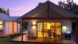 Una casa moderna con una terraza grande, un espacio exterior cubierto y un comedor.