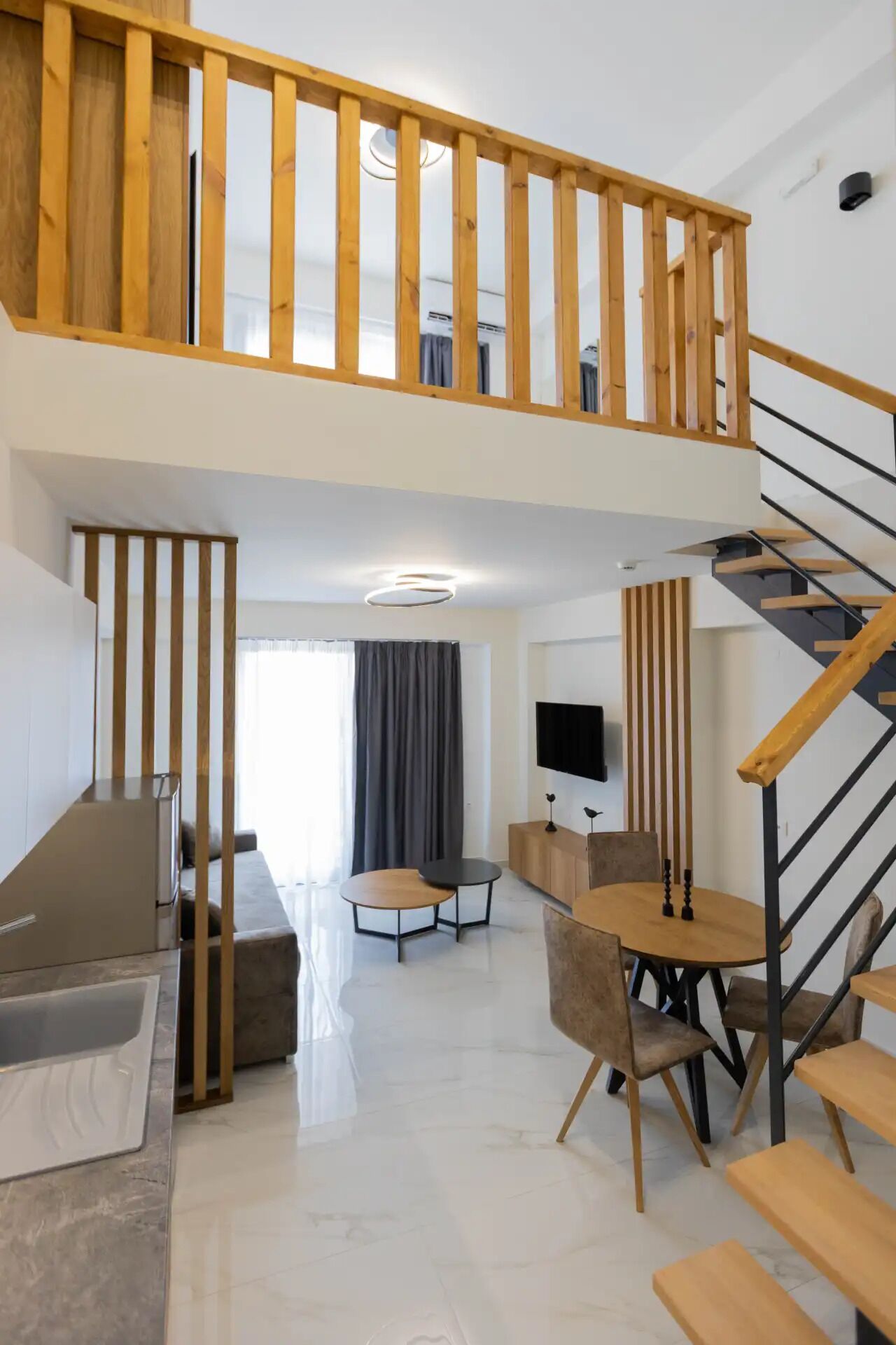 A modern apartment with a wooden staircase, a dining area, a living room, and a balcony.