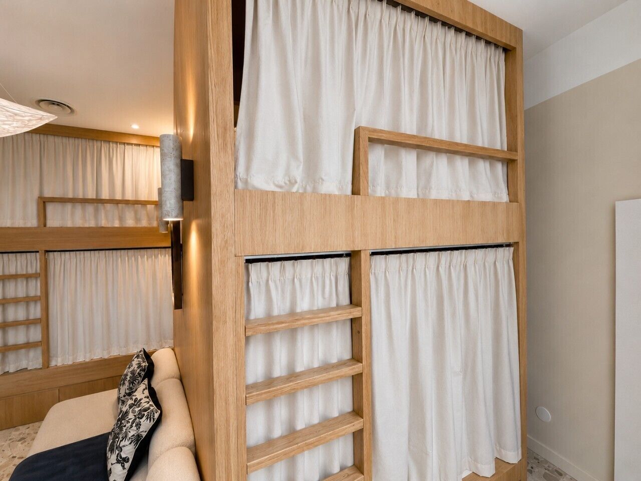 Ein Zimmer mit einem Etagenbett, Holzregalen und einer gepolsterten Sitzbank.