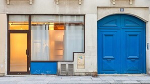 Ein Gebäude mit einer blauen Tür und einem großen Fenster mit Glastür.