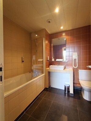 Et moderne badeværelse med badekar, vask og toilet.