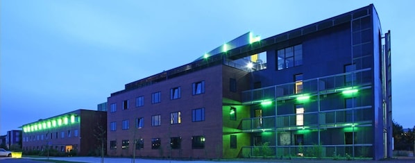 En moderne bygning med flere etager, store vinduer og et fladt tag.