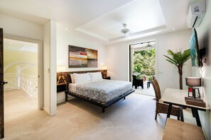 A bedroom with a bed, a desk, a chair, a lamp, and a large window. - Buendía Lux • Villa Harmonia. Stunning 3 king beds with pool near the beach. (Potrero)