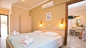 Ein Hotelzimmer mit zwei Betten, einem Schreibtisch, einem Stuhl, einer Klimaanlage und einem Spiegel.