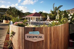 A wooden sign with 'TROPICAL' and 'St. Barth' indicating a tropical-themed location. - Tropical Hotel and Beach (St. Barthelemy)