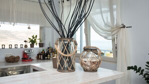 Two rustic vases with rope handles on a kitchen counter, a coffee machine, and a window with a view. - Althea Boutique Hotel (Karpathos)