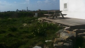 Ein weißes Gebäude mit einer Holzterrasse und einem Picknicktisch.