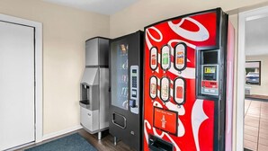 A hotel room with a minibar, a refrigerator, and a Coca-Cola branded beverage dispenser. - Americas Best Value Inn Martinsburg (Martinsburg)