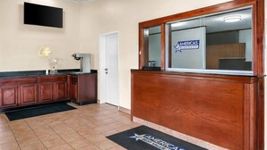 A hotel reception area with a wooden reception desk, a flat-screen TV mounted on the wall, and a neon sign that reads "Office". - Americas Best Value Inn Martinsburg (Martinsburg)