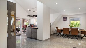Une cuisine moderne avec un coin repas, une grande fenêtre et une vue sur l’extérieur.